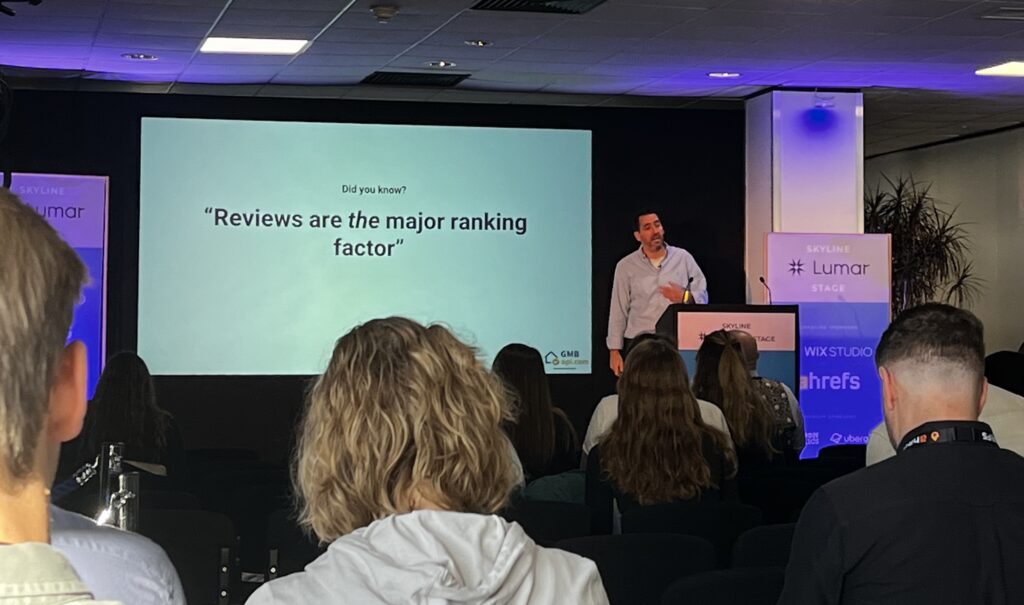 Michel van Luijtelaar discussing Local SEO on the Lumar stage at BrightonSEO – Slide text reads: "Reviews are THE major ranking factor [for local SEO]"